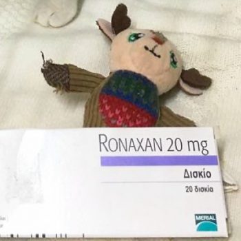 Ένας φάκελος με φάρμακα που χρειάζεται μια άρρωστη γάτα πάνω σε ένα γατοπαίχνιδο.